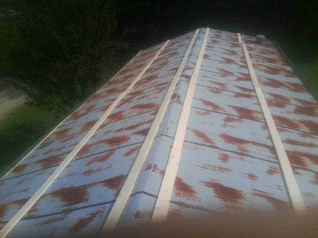 Rusted metal roof panels with new wood purlins before replacement — Storm Damage Roof Repair in Bowersville by Roofing Brothers