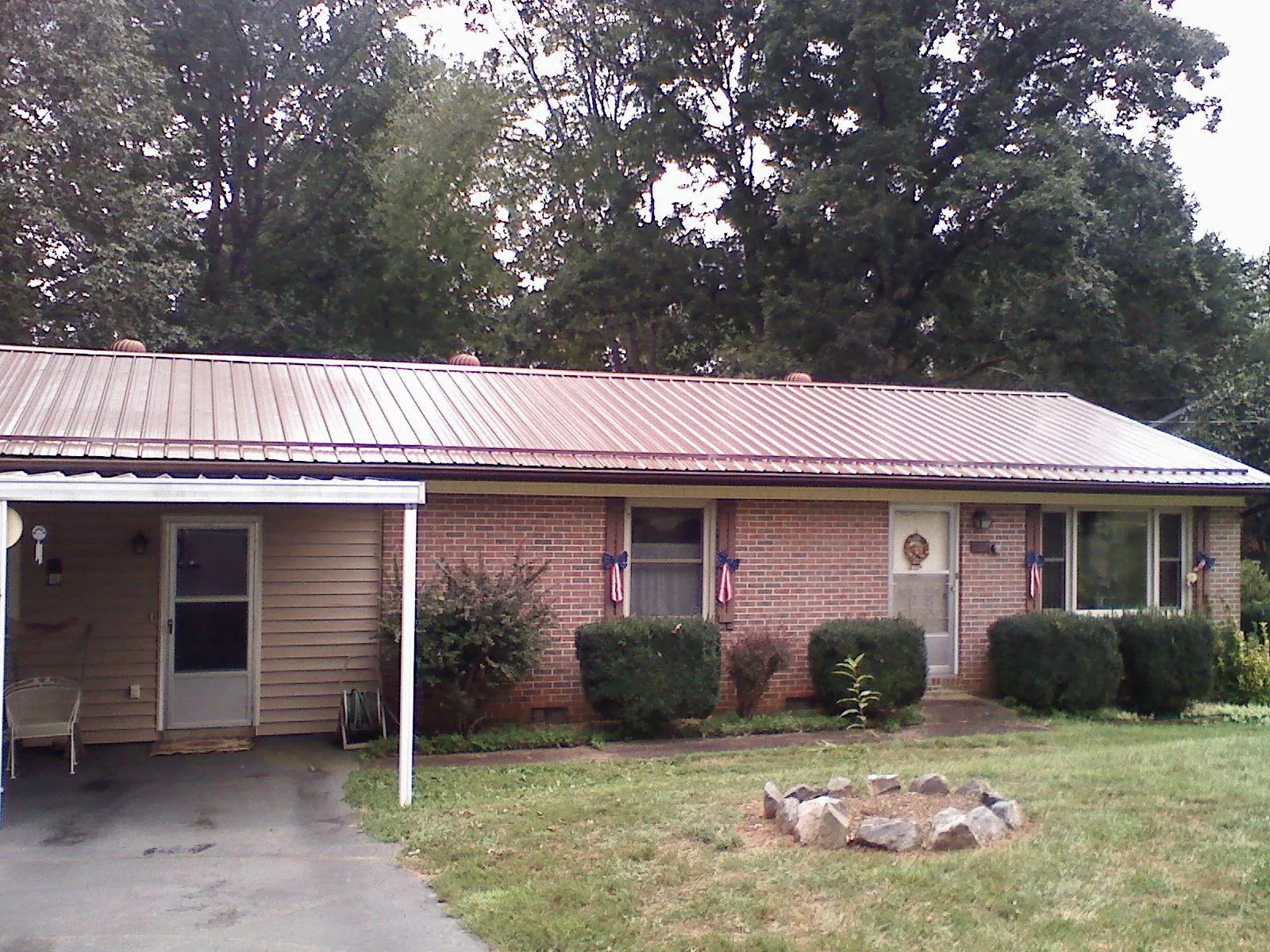 Bronze metal roof and carport on a brick ranch home — Roof Repair work by our crew in Bowersville
